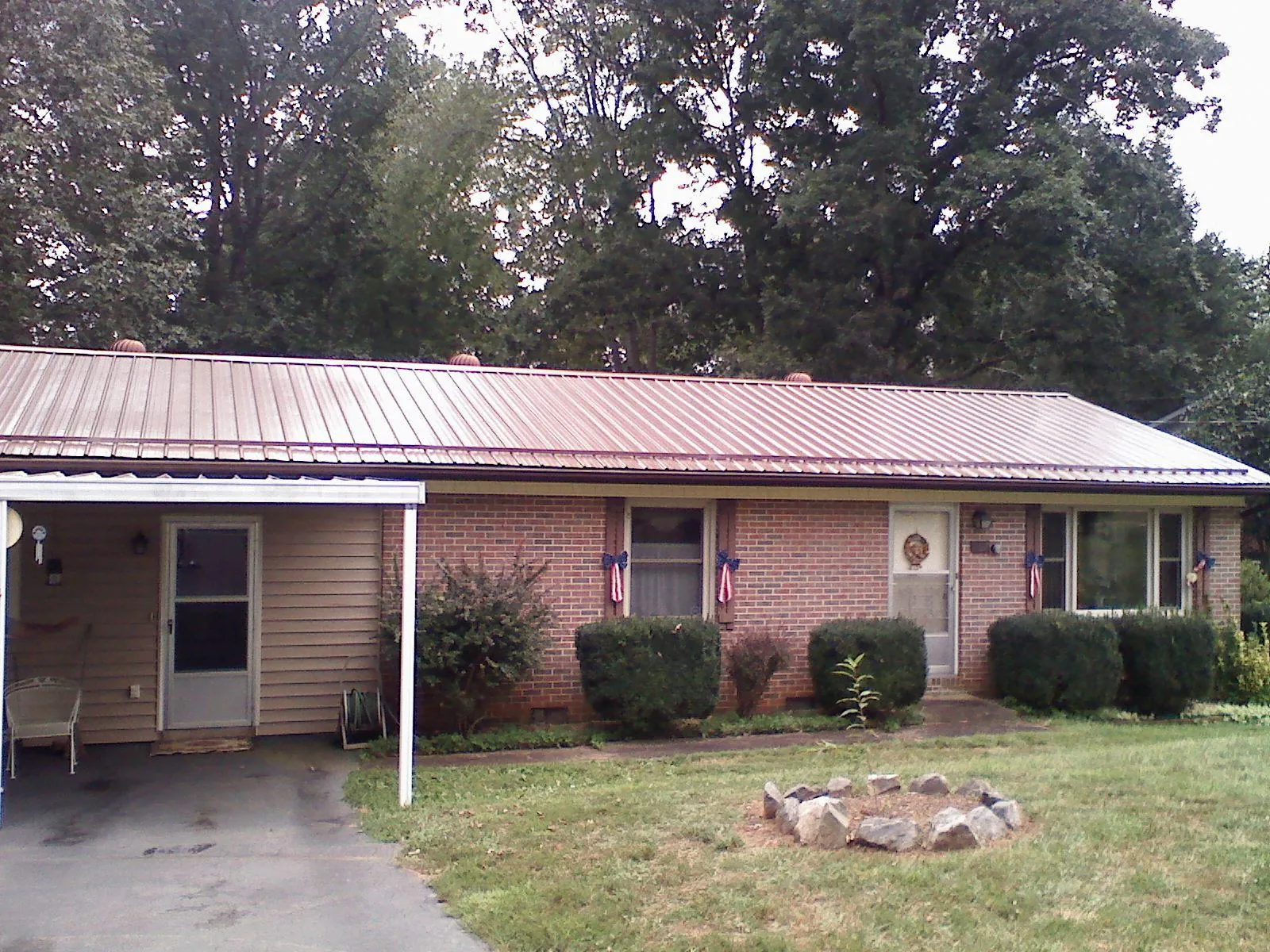 Bronze metal roof and carport on a brick ranch home — Roof Repair work by our crew in Ambrose